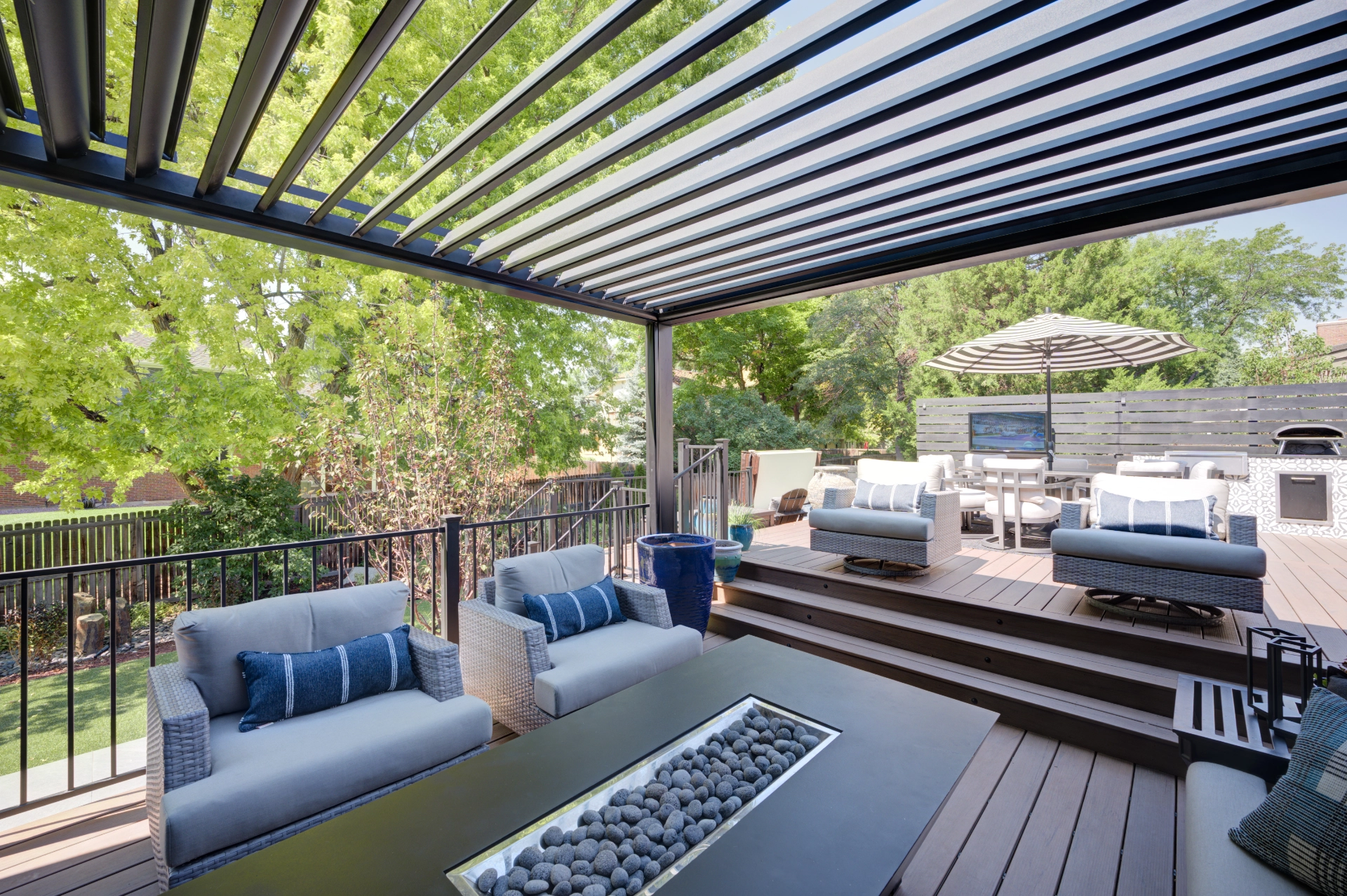 Composite Deck with a louvered pergola and a fire pit and couches